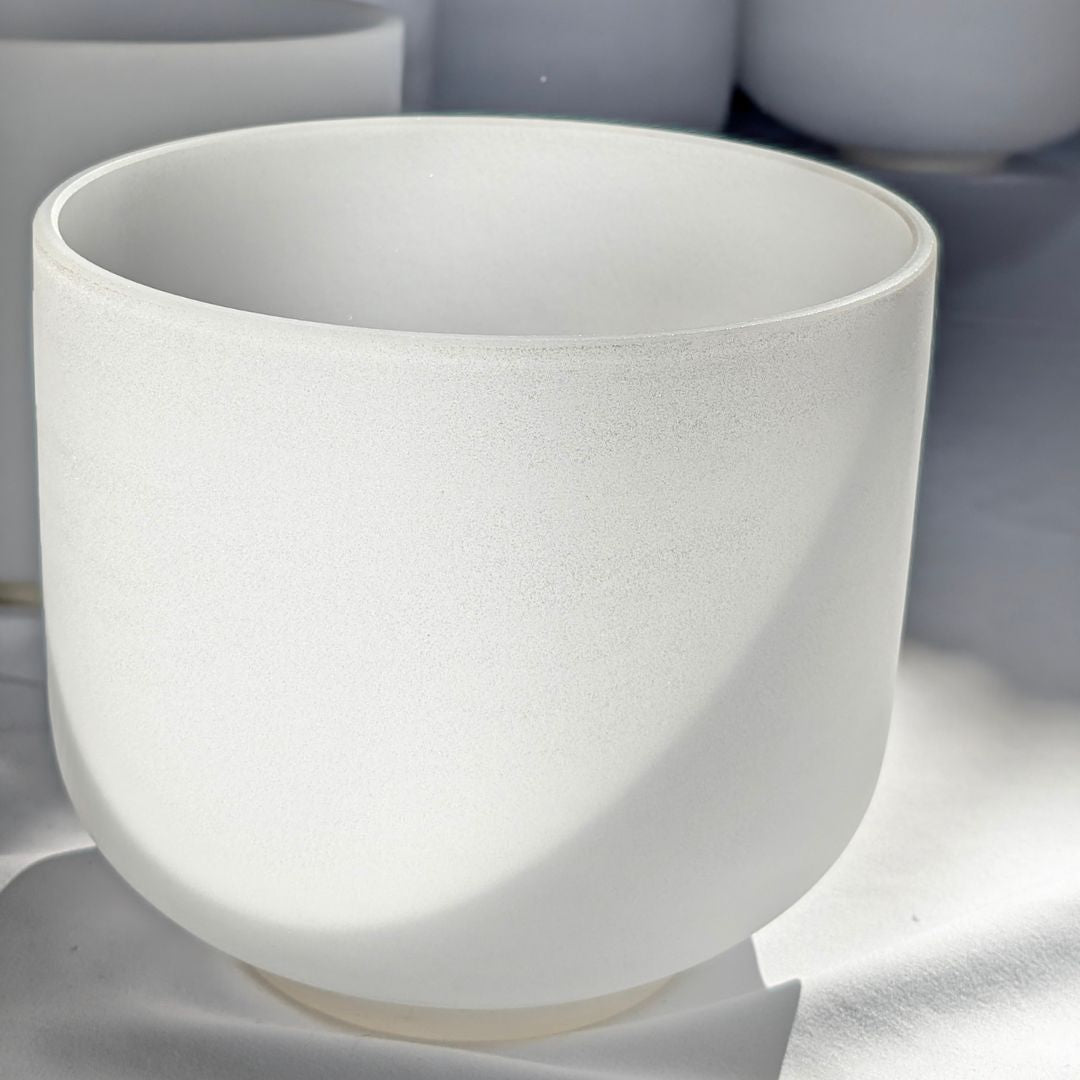 frosted crystal singing bowl on a white surface with blurred background