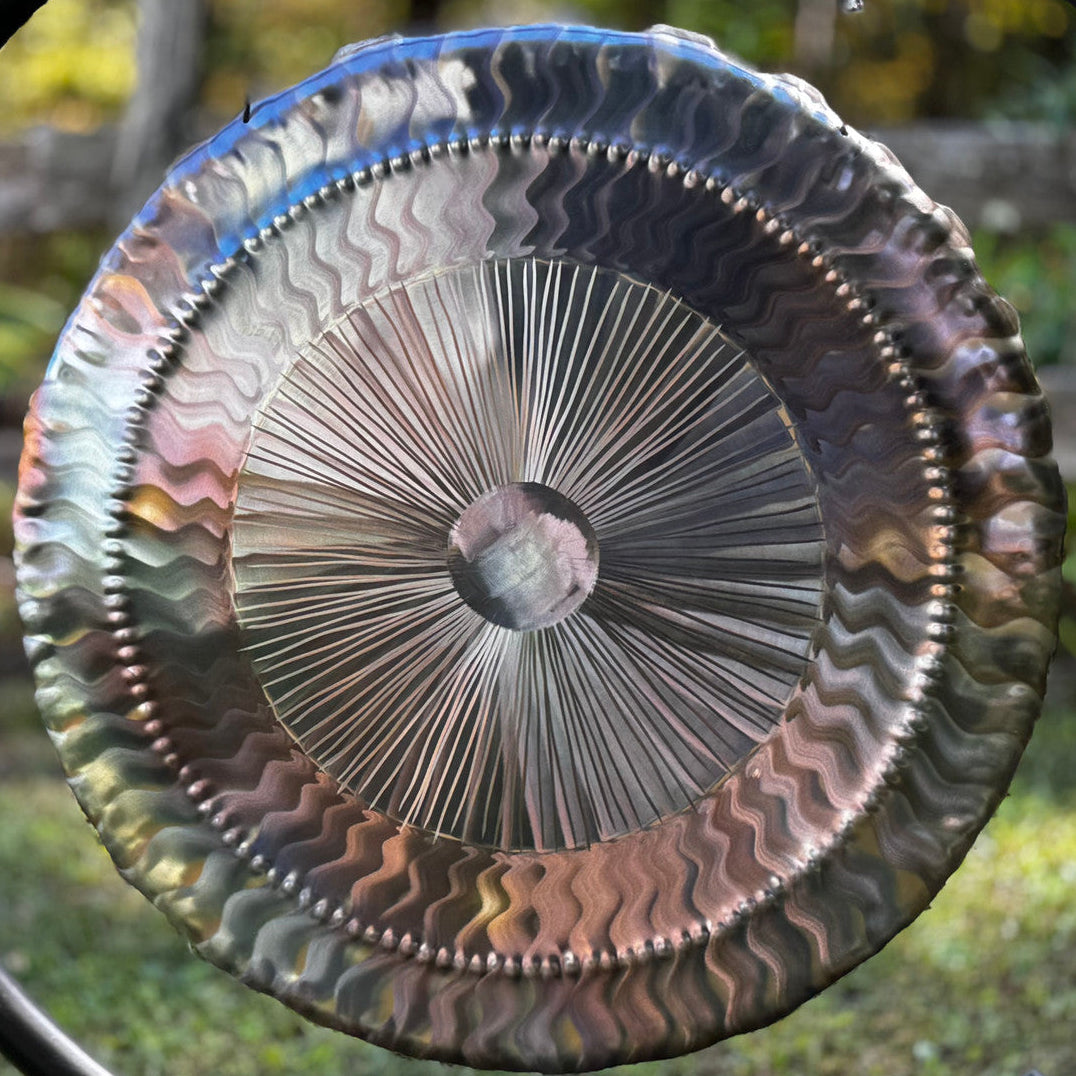 Decorative metal gong with a textured surface outdoors