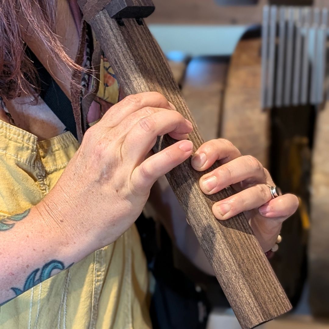 Person playing a wooden flute with a blurred background