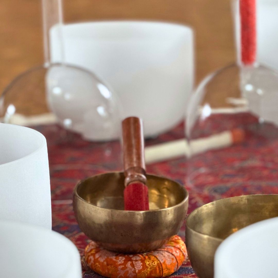metal singing bowl with a mallet on a small bowl cushion 